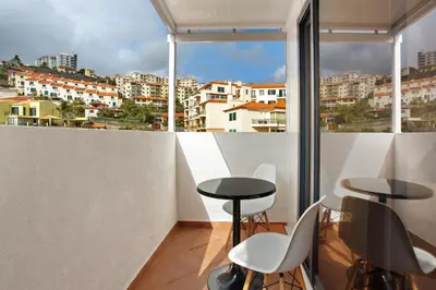 a balcony with two tables and a view of a city at Apartamento Lolita com Terraço in Caniço