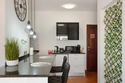 a kitchen with a counter and a table with chairs at Apartamento Lolita com Terraço in Caniço
