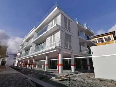 a large white building with red and white columns at Apartments Madeira Barreirinha in Funchal