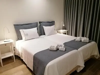 a bedroom with a large white bed with two alarm clocks on it at Apartments Madeira Barreirinha in Funchal