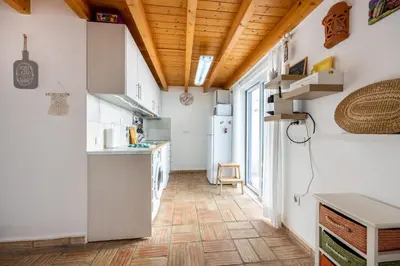a kitchen with white cabinets and a wooden ceiling at Casa Joia by Seewest in Bensafrim