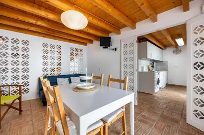a kitchen and dining room with a white table and chairs at Casa Joia by Seewest in Bensafrim