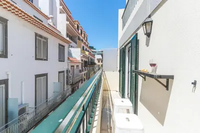 a living room with a blue chair and a table at Cosy Central by Atlantic Holiday in Funchal