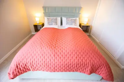 a bedroom with a large red bed with two lamps at Villa Sundowner in Prazeres