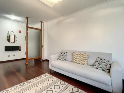a living room with a white couch and a rug at Milagres Apartment by Atlantic Holiday in Machico