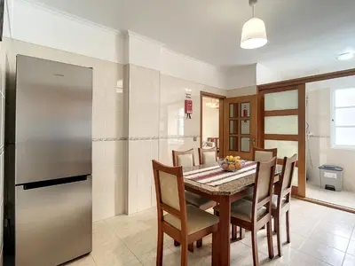 a kitchen with a table and chairs and a refrigerator at Milagres Apartment by Atlantic Holiday in Machico