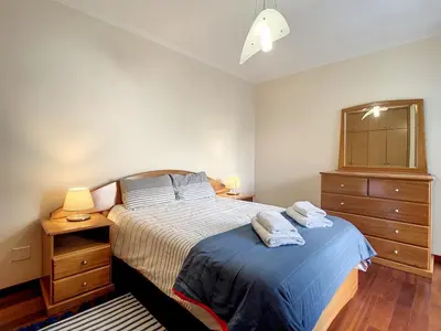 a bedroom with a bed and a dresser with two towels at Milagres Apartment by Atlantic Holiday in Machico