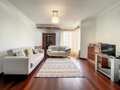 a living room with a white couch and a tv at Milagres Apartment by Atlantic Holiday in Machico
