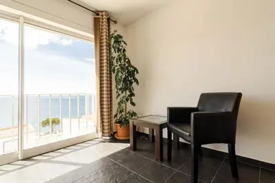 a black chair and a table in a room with a window at apartment with amazing sea view in Burgau