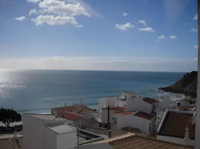 a view of a town with the ocean in the background at apartment with amazing sea view in Burgau