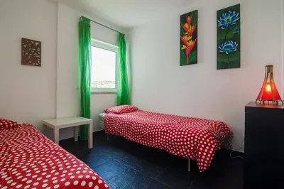 a room with two beds and a window with green curtains at apartment with amazing sea view in Burgau