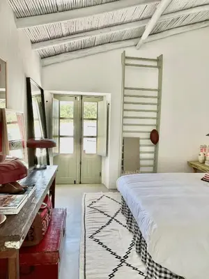 a bedroom with a large bed and a table at Casa da Oliveira - Monte Branco in Aljezur