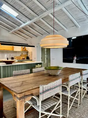 a dining room with a wooden table and chairs at Casa da Oliveira - Monte Branco in Aljezur