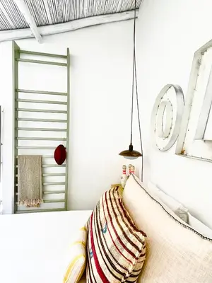 a white room with a couch and a mirror at Casa da Oliveira - Monte Branco in Aljezur