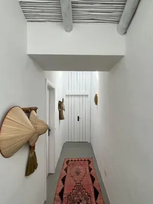 a hallway with white walls and a ceiling with a rug at Casa da Oliveira - Monte Branco in Aljezur