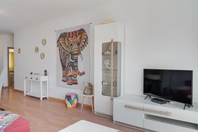 a living room with a television and a white cabinet at Alta do Garajau II in Caniço