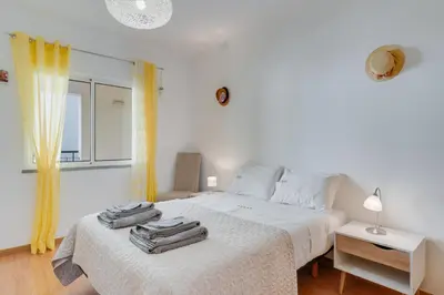 a bedroom with a white bed with towels on it at Alta do Garajau II in Caniço