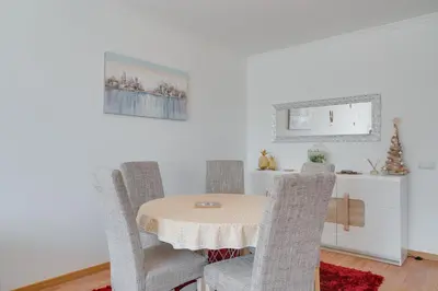 a dining room with a table and chairs at Alta do Garajau II in Caniço
