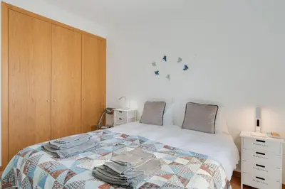 a bedroom with a bed and a wooden cabinet at Alta do Garajau II in Caniço