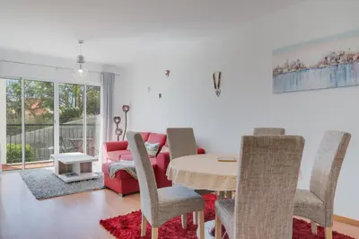 a living room with a table and a red couch at Alta do Garajau II in Caniço