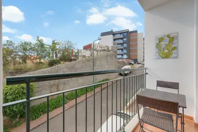 a balcony with a bench and a view of a city at Alta do Garajau II in Caniço