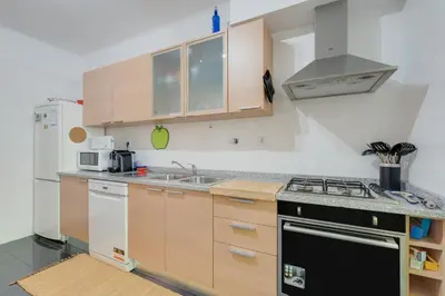 a kitchen with wooden cabinets and a stove top oven at Alta do Garajau II in Caniço