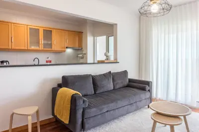 a living room with a couch and two tables at Madeira Sea View Apartment in Caniço