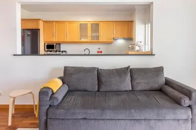 a living room with a couch and a kitchen at Madeira Sea View Apartment in Caniço