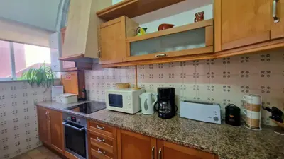 a kitchen with wooden cabinets and a microwave at Lighthouse Apartment in Luz
