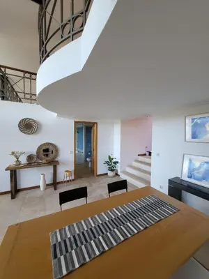 a dining room with a table and chairs and a staircase at Lighthouse Apartment in Luz