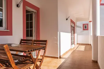 a dining room with a wooden table and chairs at cozy sunny peaceful flat with swimming pool in Burgau