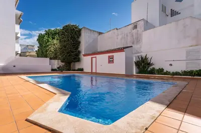 a swimming pool in front of a building at cozy sunny peaceful flat with swimming pool in Burgau