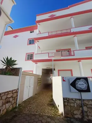 a white building with a sign in front of it at cozy sunny peaceful flat with swimming pool in Burgau