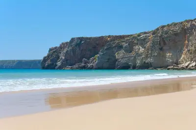 a sandy beach with cliffs in the background at Villa Alcione in Sagres
