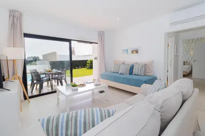 a white living room with a couch and a table at Villa Alcione in Sagres
