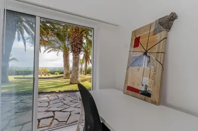 a dining room with a window and a painting on the wall at Dune Beach CoLiving in Porto Santo
