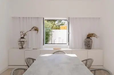 a dining room with a table and chairs and a window at Dune Beach CoLiving in Porto Santo