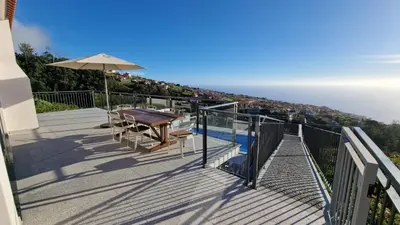 a balcony with a table and an umbrella at Casa Bella Vista - Calheta in Arco da Calheta