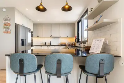 a kitchen with two blue chairs and a counter at Casa Bella Vista - Calheta in Arco da Calheta