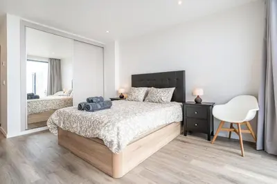 a bedroom with a bed and a mirror and a chair at Casa Bella Vista - Calheta in Arco da Calheta