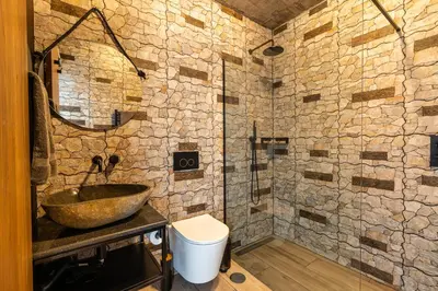 a stone bathroom with a sink and a shower at Casa Bella Vista - Calheta in Arco da Calheta