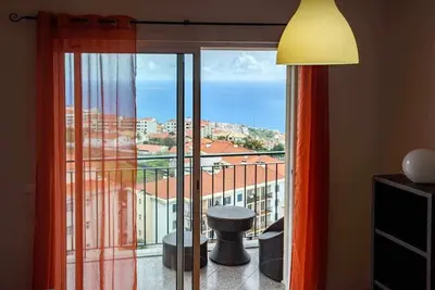 a room with a large window with a view of the ocean at Garajau Ocean View in Caniço
