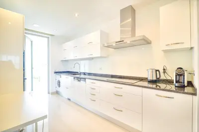 a white kitchen with white cabinets and a appliance at WIOLA SeaView Apartment by MOJE Holiday in Lagos