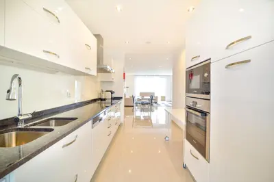 a white kitchen with a sink and a stove at WIOLA SeaView Apartment by MOJE Holiday in Lagos