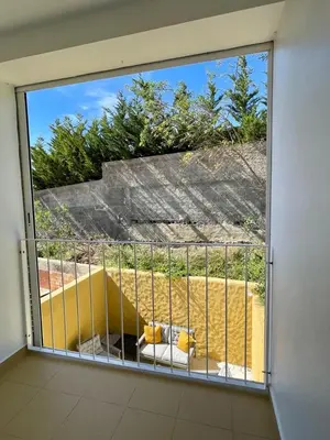 a balcony with a large window with a couch on it at Maria da Vinha Porto Santo Beach House in Porto Santo