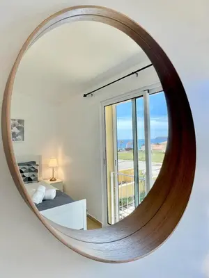 a mirror in a room with a bed and a window at Maria da Vinha Porto Santo Beach House in Porto Santo