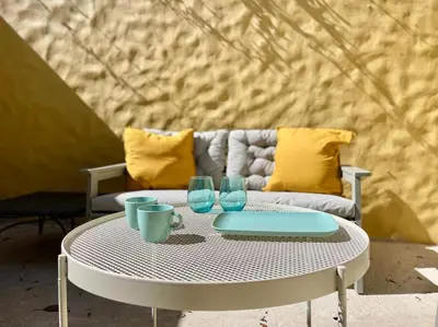 a white table with two glasses and a couch at Maria da Vinha Porto Santo Beach House in Porto Santo