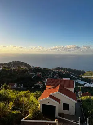 a house on a hill with the ocean in the background at Slice of ponta do sol Room 1 in Ponta do Sol