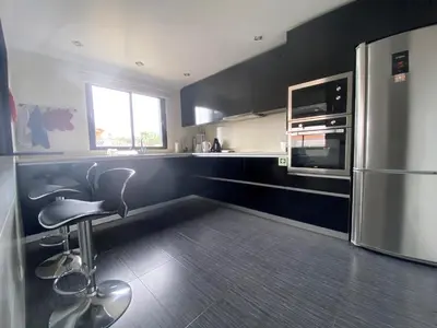 a kitchen with a refrigerator and a chair in it at Villa Madeira island in Caniço