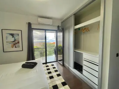 a bedroom with a bed and a sliding glass door at Villa Madeira island in Caniço